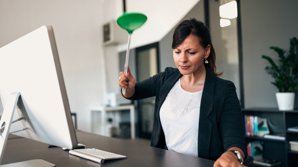 Determined businesswoman with a flyswatter picture id980241368
